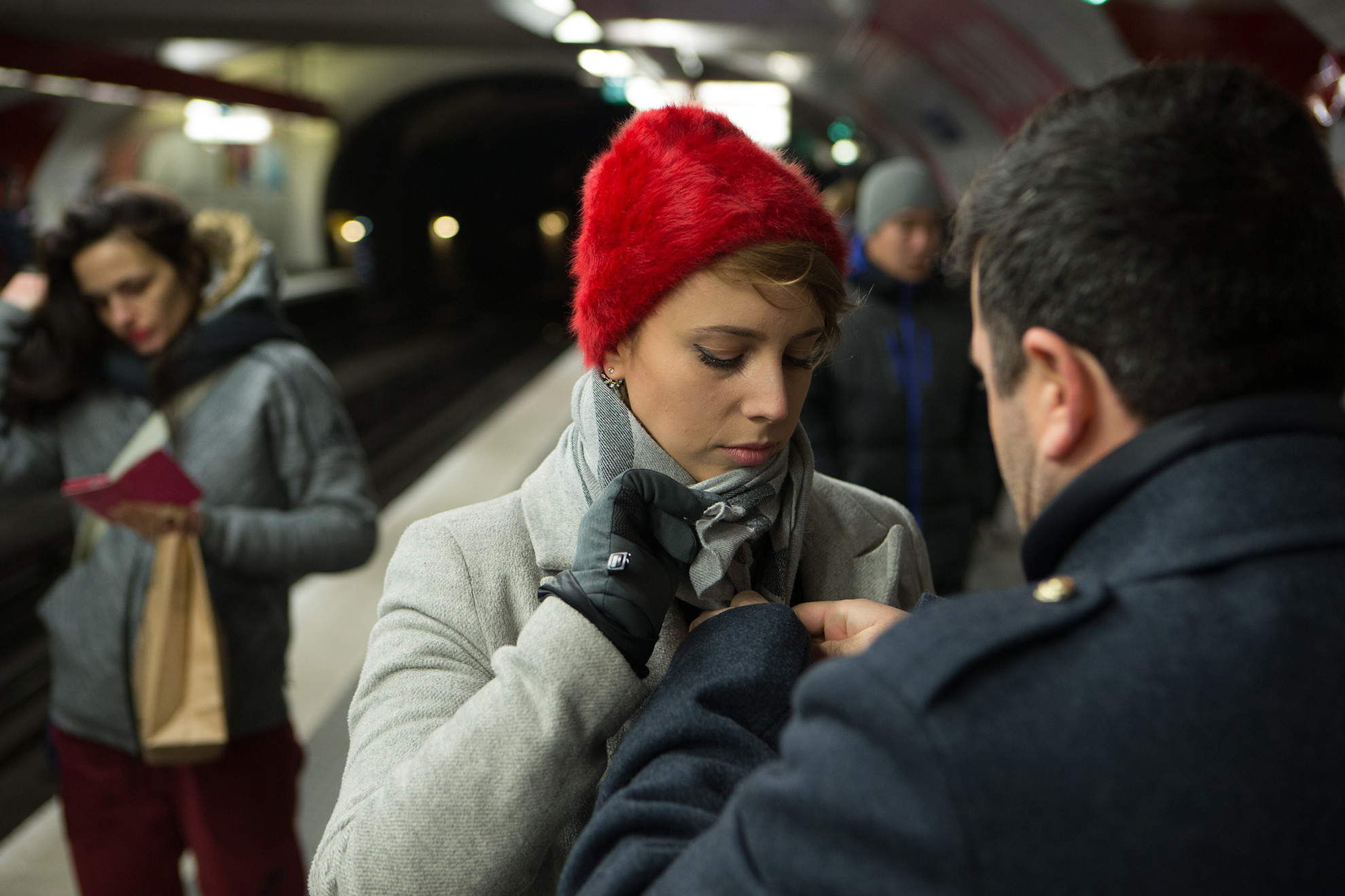 אשה בכובע צמר אדום בתחנת רכבת תחתית