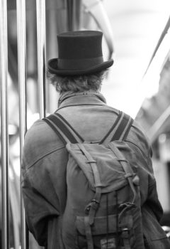 The back of man with a tall hat and a backpack